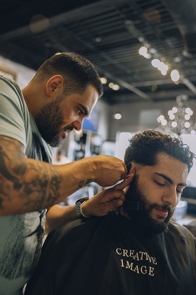 Mohammad Jaafar receives a haircut from his barber Ali Nasraldin. Both men are Lebanese Americans and originate from the same small village of Qmatiye in central Lebanon. Ali immigrated to the US in 2011 from Lebanon to create a better life for him and his family. In Lebanon Ali was working as a barber for many years and like many in Lebanon was struggling to get by. Ali’s immigration to Dearborn has allowed him to support his family and save up enough to visit Lebanon at least twice a year. Ali is well aware of the current ongoing economic crisis in Lebanon and how much his family back home relies on him. He appreciates his salary in Dearborn for what it is. It allows him to get by every month and to help out family back home with financial support.  

Mohammad gets his haircut at least once a month and looks forward to the day where he gets his “Dearborn fade”, a common haircut among Dearborn’s Arab male population. Mohammad says, “Even if it is just a small act of pampering, everyone in Dearborn, regardless of income, gets a fresh fade. We exist in a world built around stress over finances. Whether it is my car payment, student loan debt, or bills. Being able to at least pamper myself once a month in order to look and feel well-groomed is important to me.”